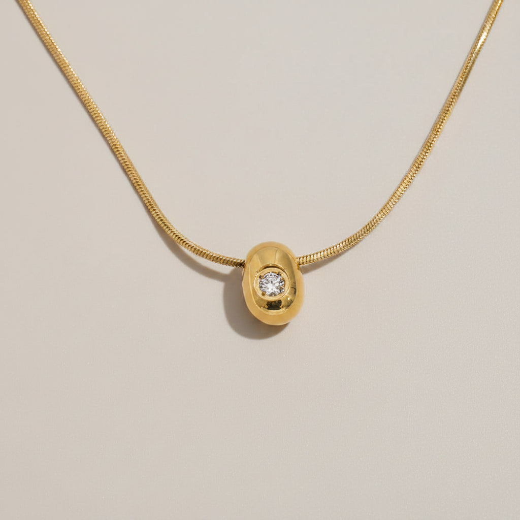 Gold necklace with a pendant featuring a diamond